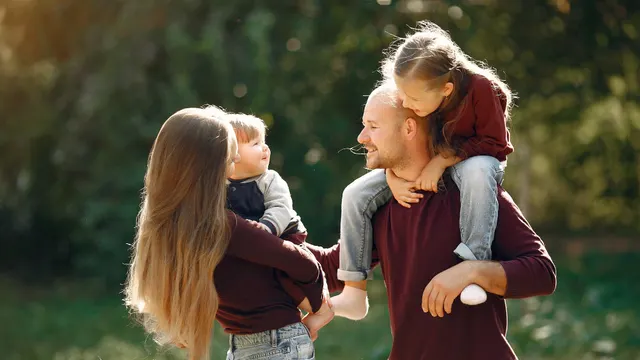 Parent et enfant adulte discutant d'un projet financier autour d'une table, documents et tablette devant eux