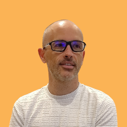 Jérôme Guilloux, pull jaune, bras croisés, sourire, fond mer turquoise – Qui suis-je Loany