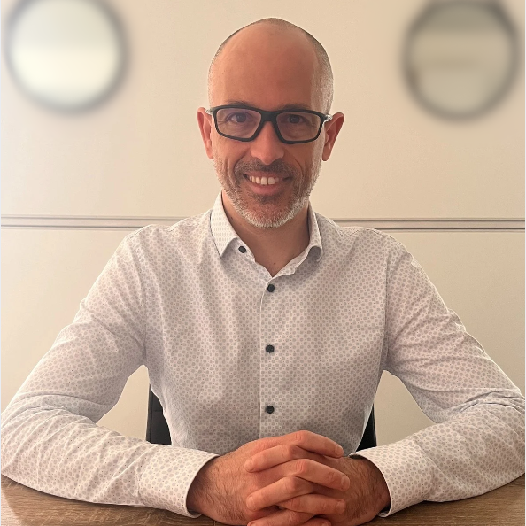 Portrait de Jérôme Guilloux, chemise blanche élégante, sourire – page Qui suis-je Loany